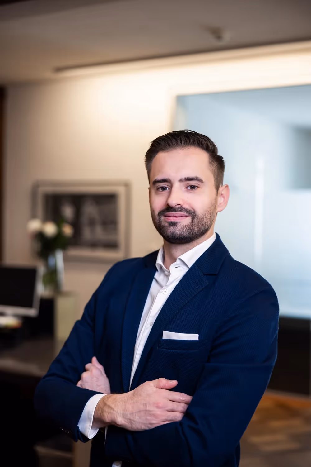 Matthias Frech mit verschränkten Armen in einem Büro.